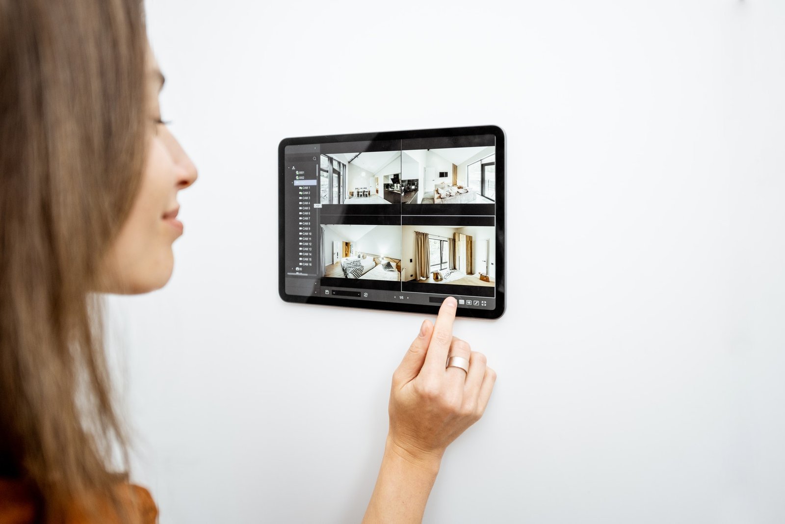 Woman controlling home with video cameras and digital tablet
